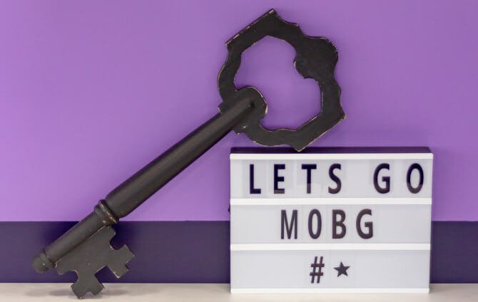 Uma chave preta grande e uma placa escrita Let's Go Mobg